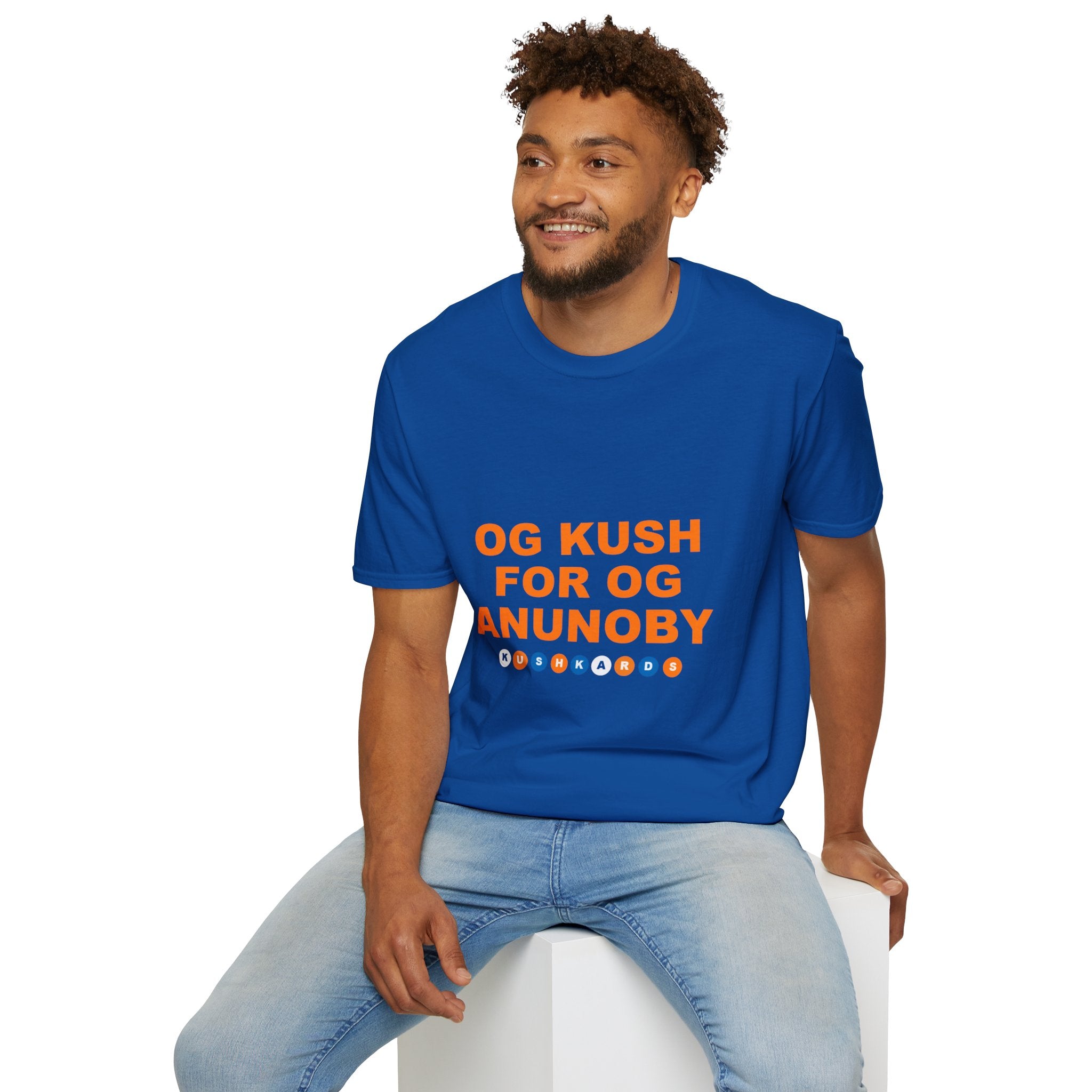 Man wearing a blue t-shirt with text, sitting on a white stool against a white background
