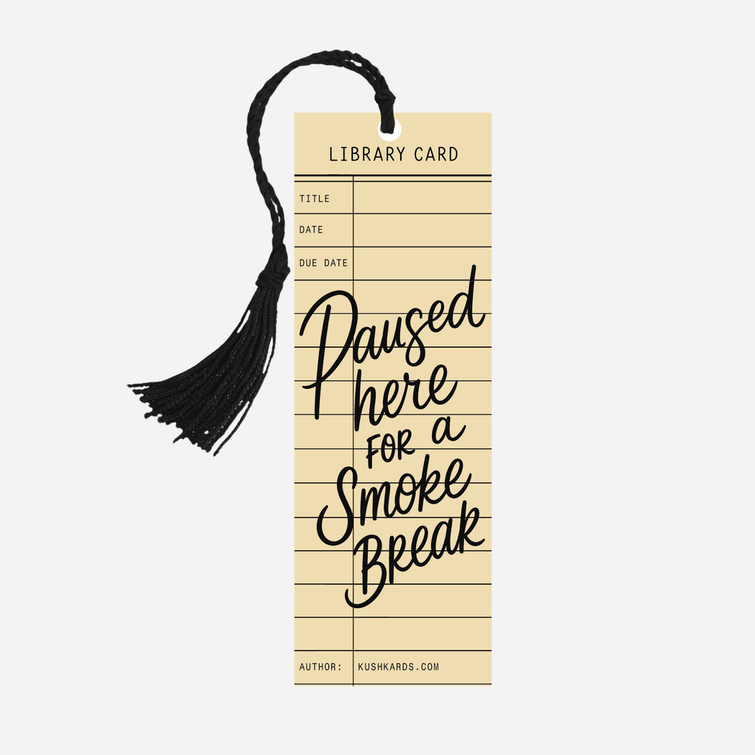 Cream-colored KushKards bookmark designed like a vintage library card with black ruled lines and a black tassel attached at the top. Large black script lettering reads “Paused Here for a Smoke Break,” with “Author: KushKards.com” printed at the bottom. Available as a single bookmark or in a 5-pack.