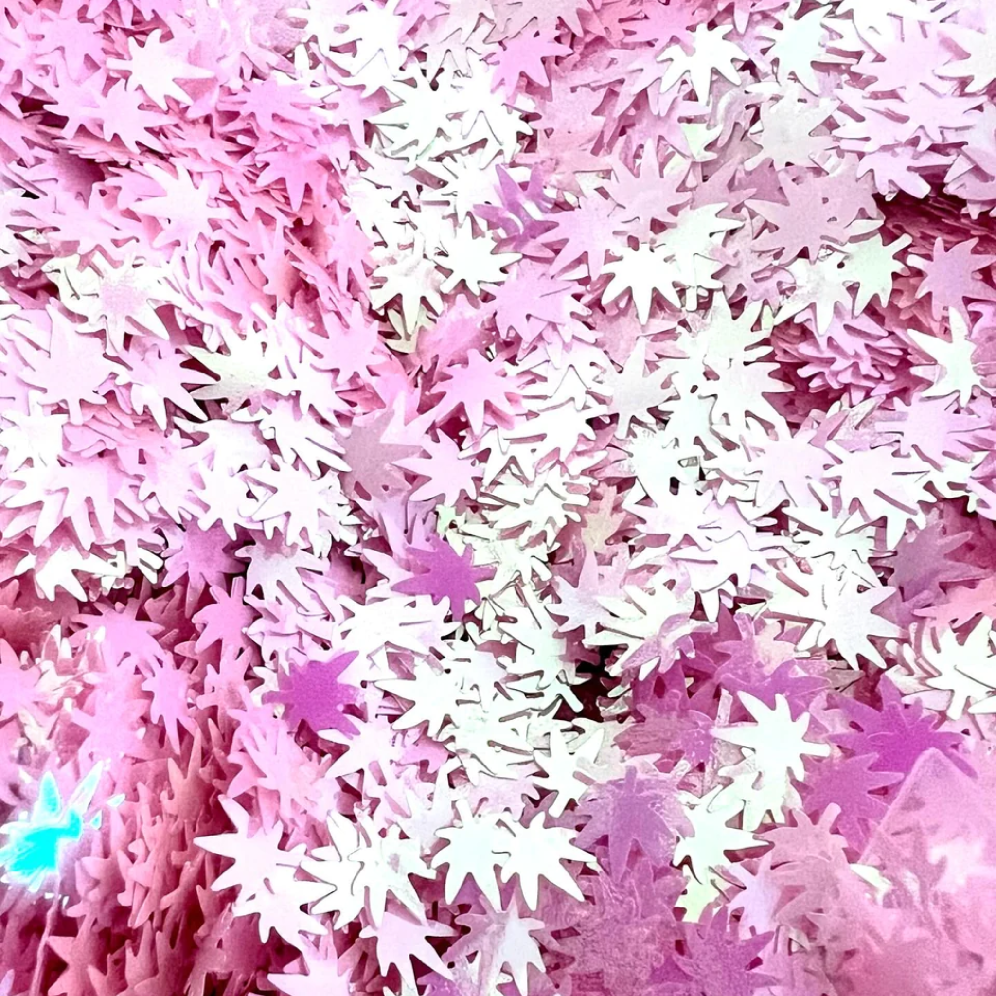 Close-up of pink cannabis leaf-shaped confetti scattered densely.