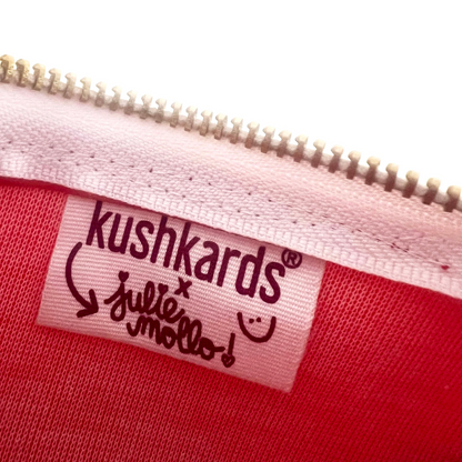 KushKards and Julie Mollo collaboration logo on a red fabric tag inside a clutch.
