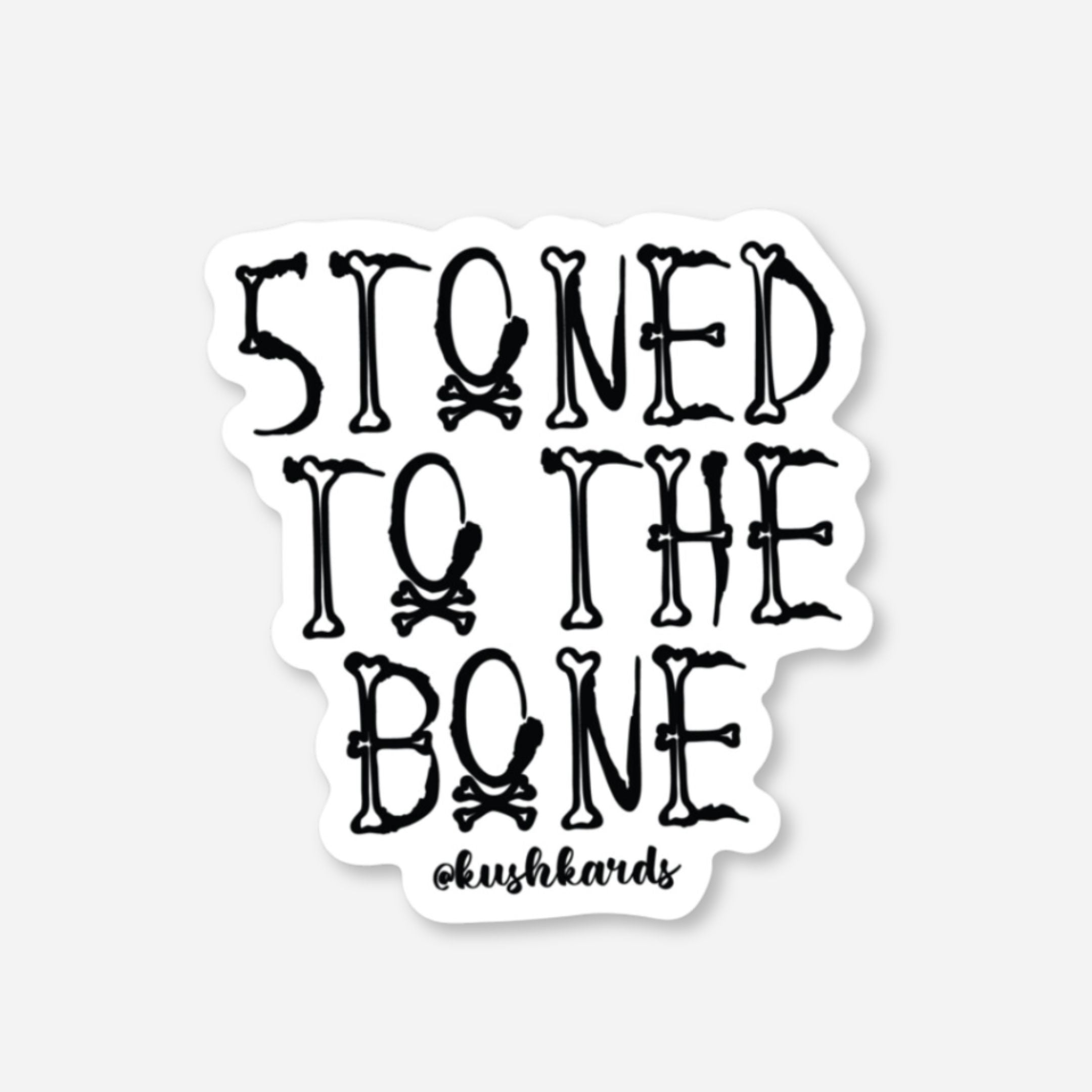 White matte sticker with "STONED TO THE BONE" text made from bones and skull & crossbones.