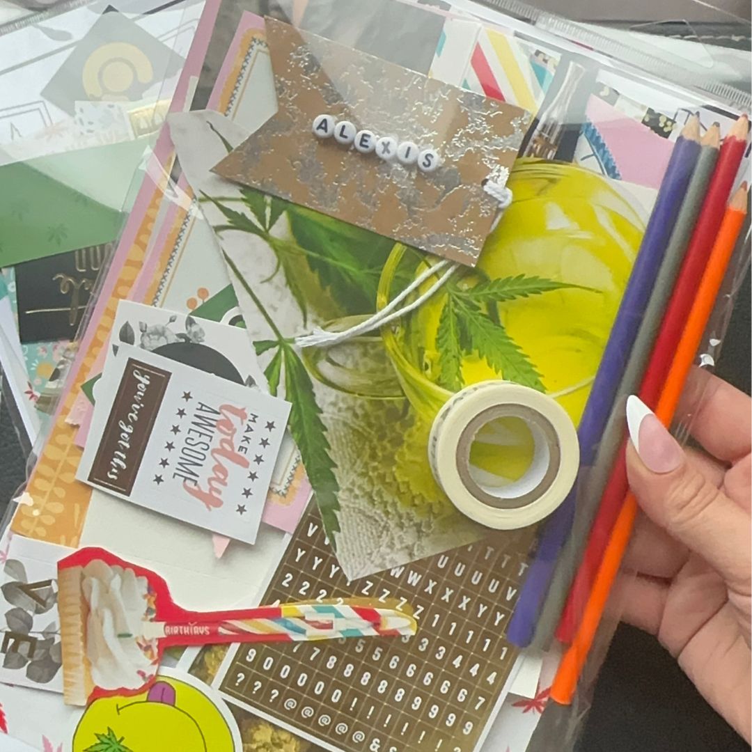 Image of stationery subscription pack wit color pencils , tape, magazine scraps and a name tag with letter beads