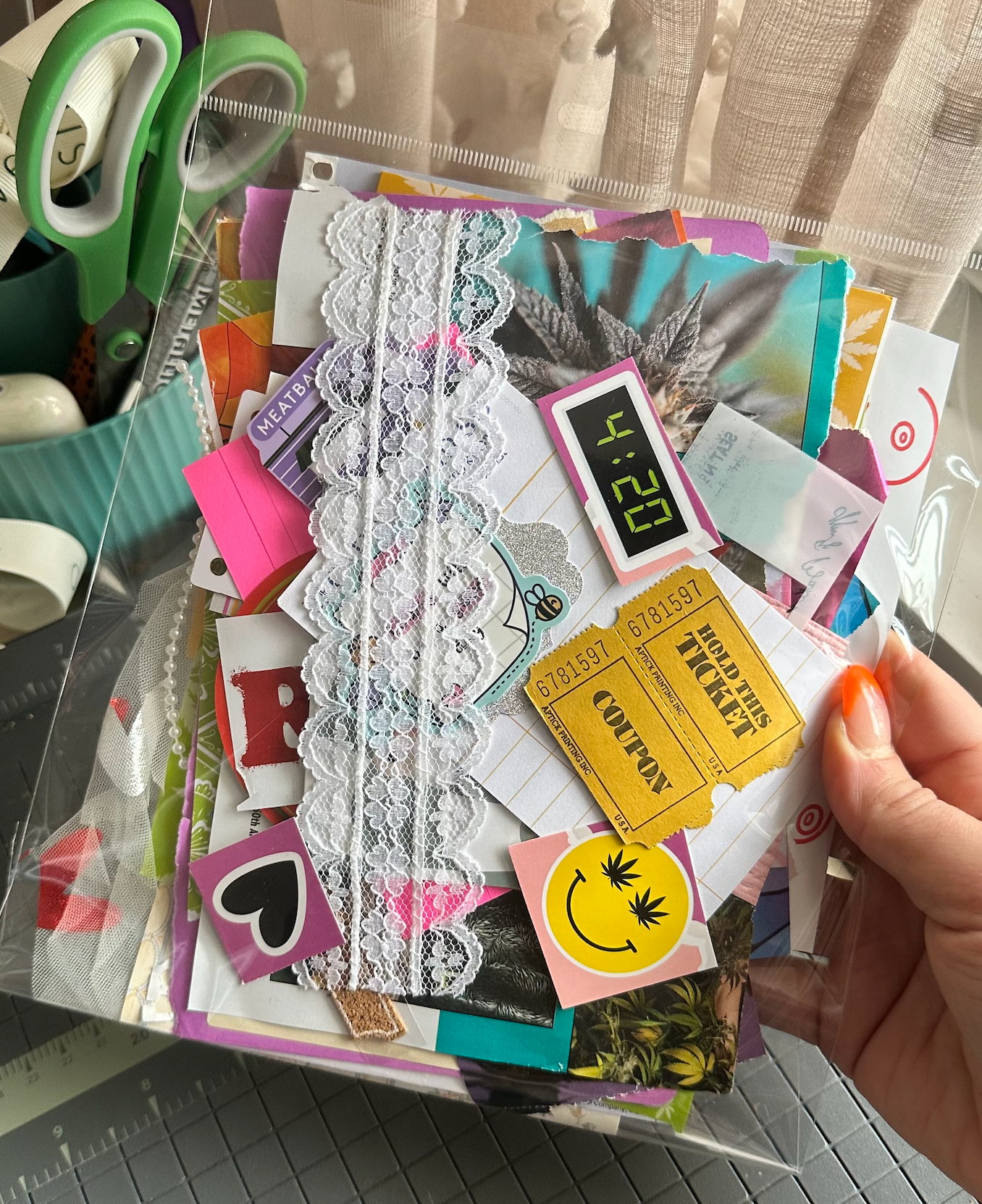 Collection of scrapbooking materials including scissors, lace, and stickers held by a hand.