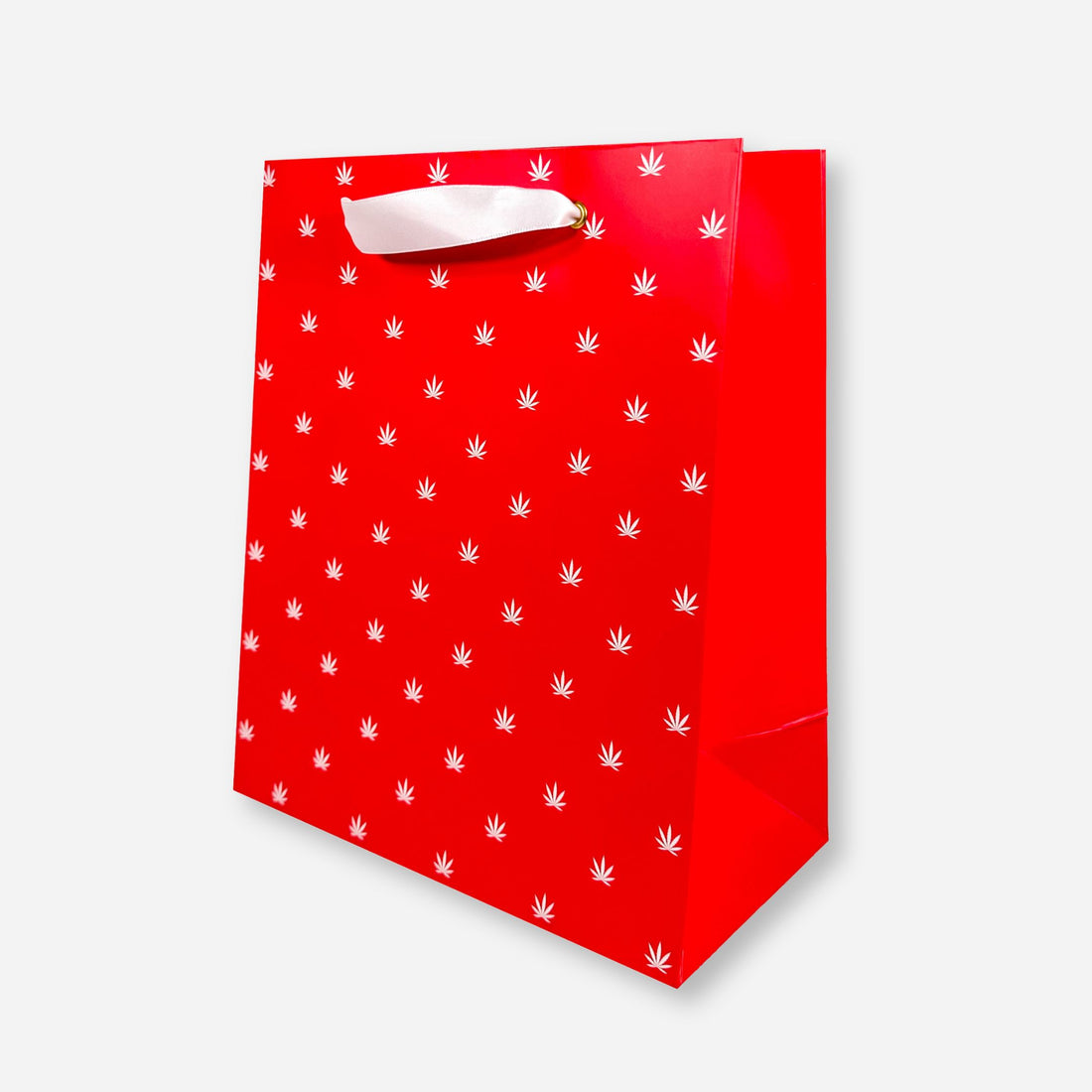 red gift bag with white foil cannabis leaf pattern and white ribbon handles.