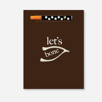 Let’s Bone KushKards greeting card featuring a rich brown background with cream lettering that reads “let’s bone” and a wishbone illustration in the center. A matching aluminum one-hitter pipe with a black-and-white floral leaf pattern and orange-speckled tip is attached near the top of the card. 