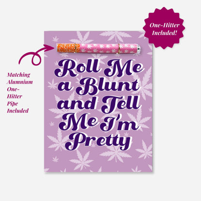 A playful cannabis-themed greeting card with bold text saying &quot;Roll Me a Blunt and Tell Me I’m Pretty,&quot; set against a purple background with leafy motifs with pink and white one hitter pipe 