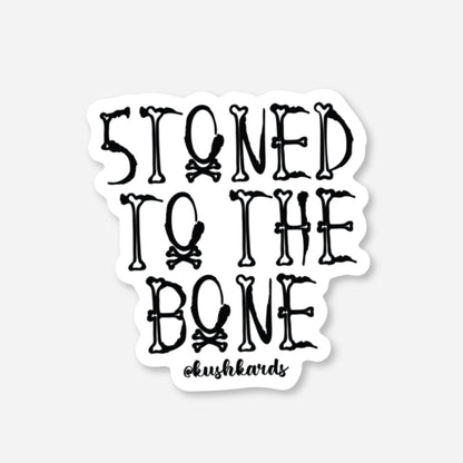White matte sticker with &quot;STONED TO THE BONE&quot; text made from bones and skull &amp; crossbones.