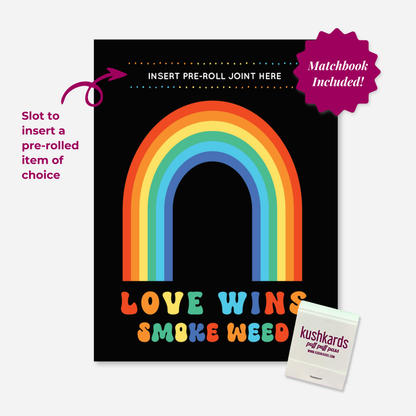 Black Greeting Card with a Rainbow and text " Love Wins Smoke Weed" in multiple colors with a slot to insert a pre roll and a branded kushkards matchbook on a light grey background 