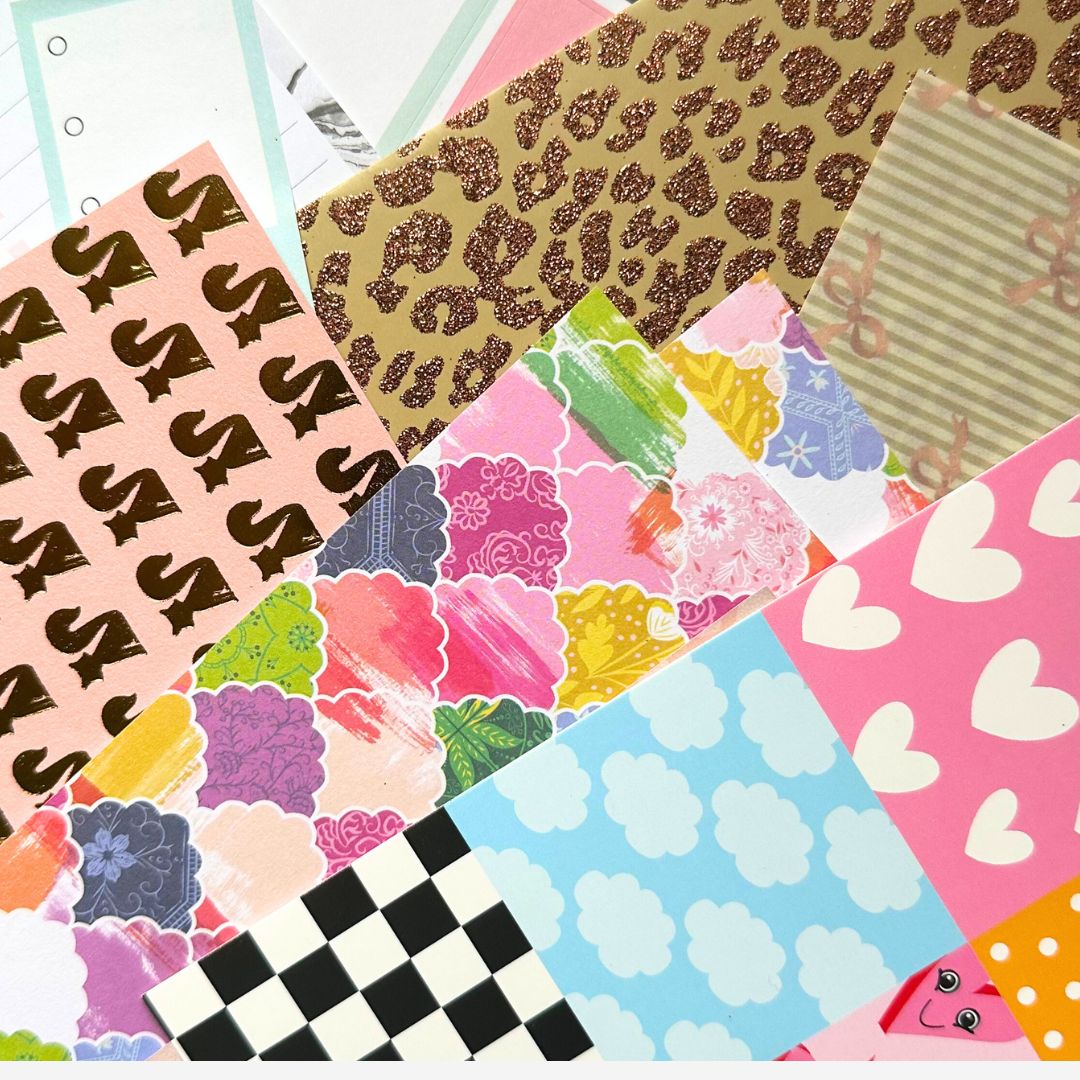 Patterned scrapbook paper set with clouds, hearts, animal print, pink S’s, checkered backgrounds, and colorful swatches for junk journals
