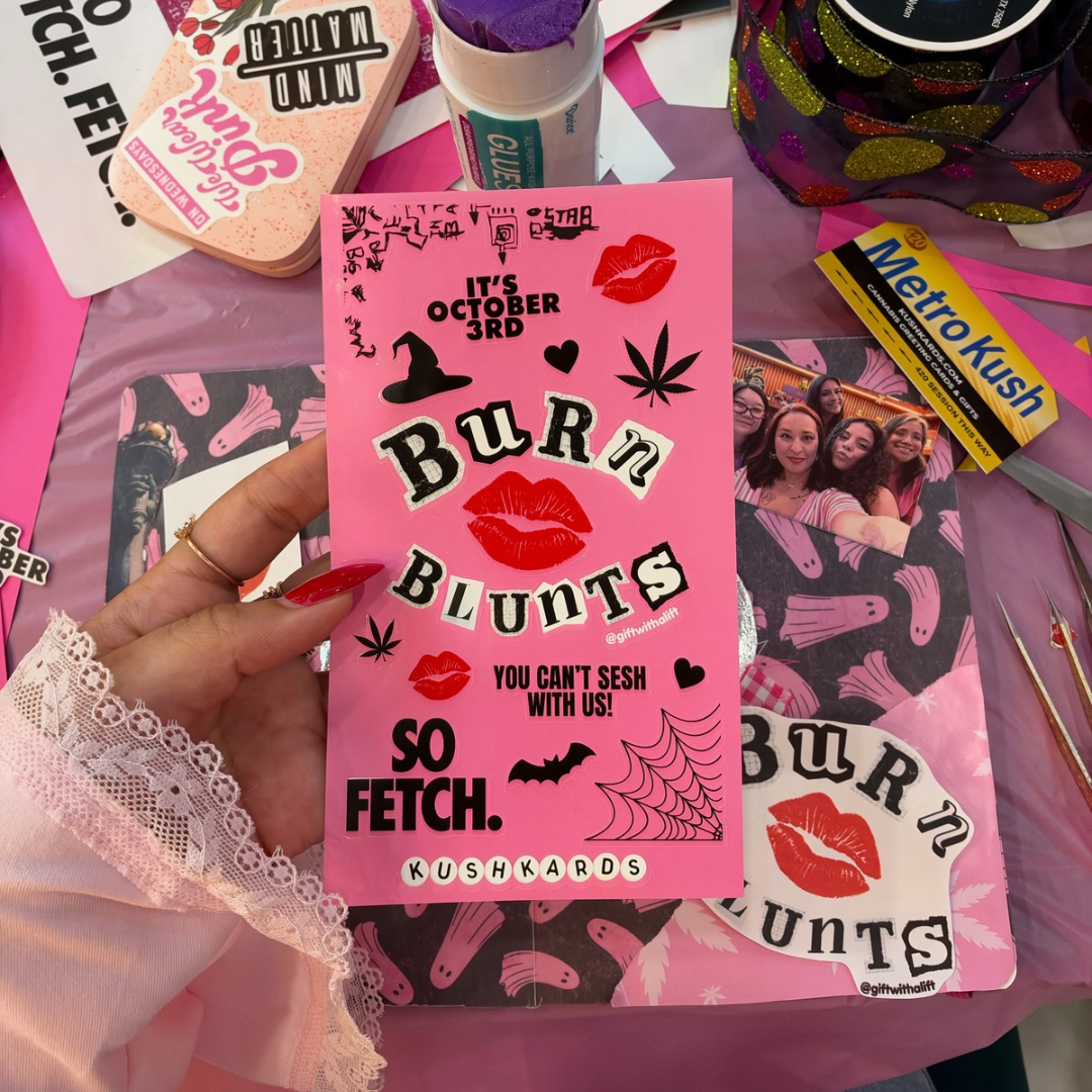 A hand with red nails holds a pink card featuring the text &