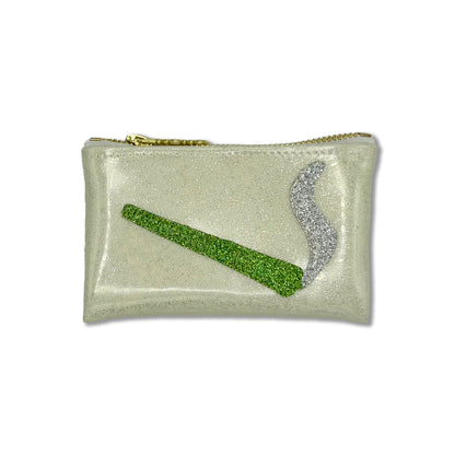 A small rectangular glitter pouch in a pale champagne color with a gold zipper, featuring a green glitter cigarette and a silver glitter smoke graphic on the front.