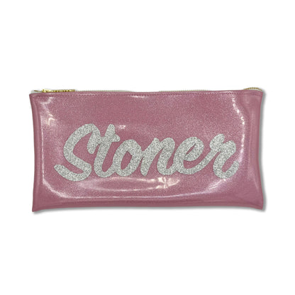 A pink glittery pouch with a gold zipper and the word &