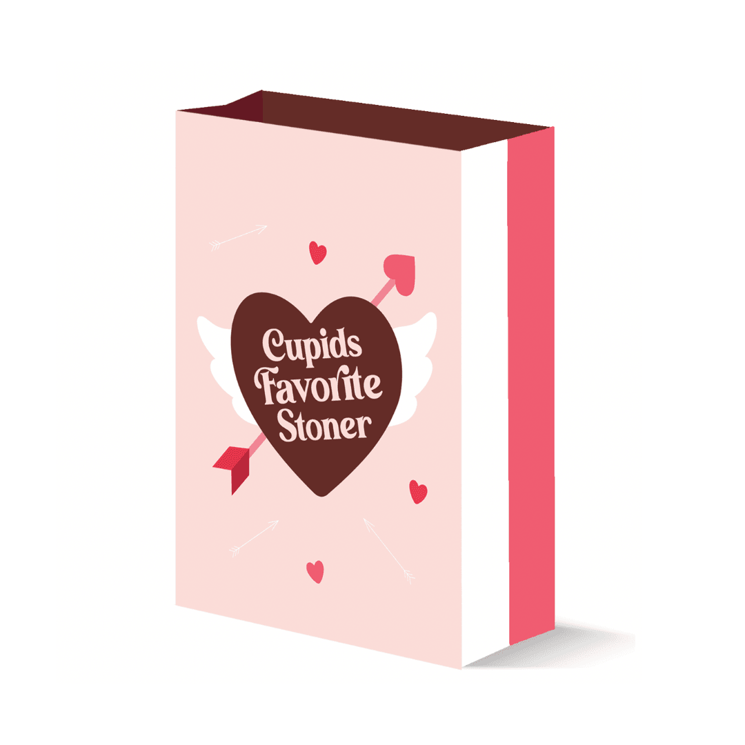 A charming pink gift bag with a whimsical design featuring the phrase 'Cupid's Favorite Stoner' inside a chocolate heart, flanked by white wings and playful arrows, creating a lighthearted blend of romance and cannabis culture.
